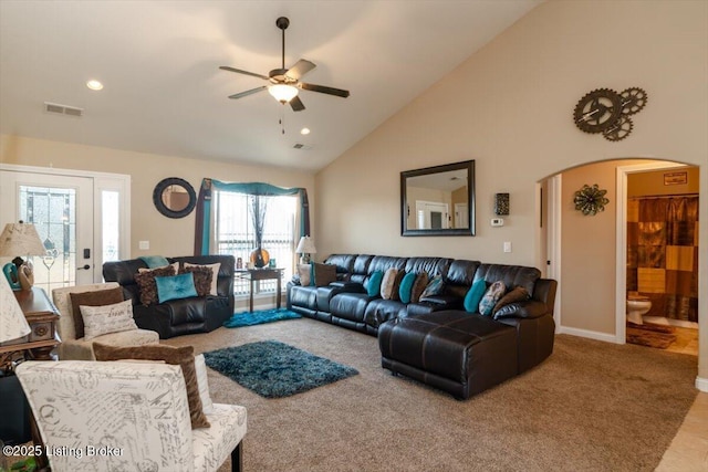 carpeted living area with arched walkways, high vaulted ceiling, recessed lighting, visible vents, and a ceiling fan