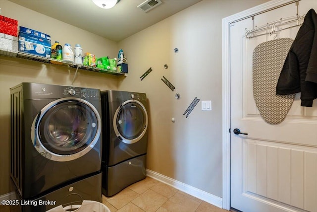 clothes washing area featuring laundry area, light tile patterned floors, baseboards, visible vents, and washer and dryer