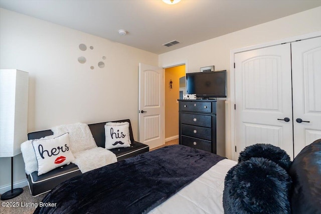 carpeted bedroom with a closet, visible vents, and baseboards