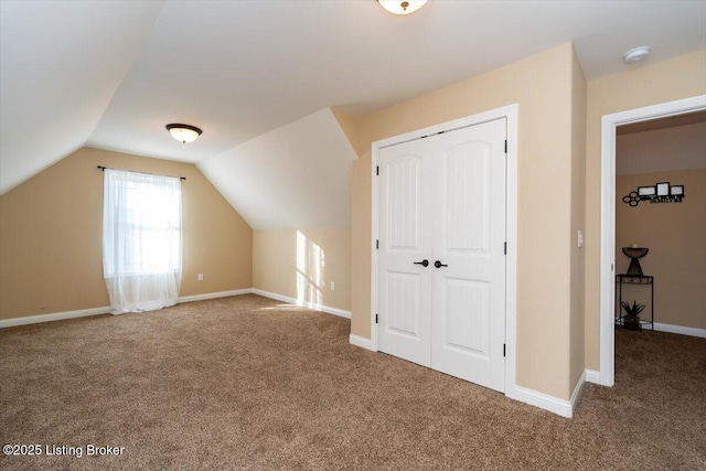 bonus room featuring baseboards, vaulted ceiling, and carpet flooring