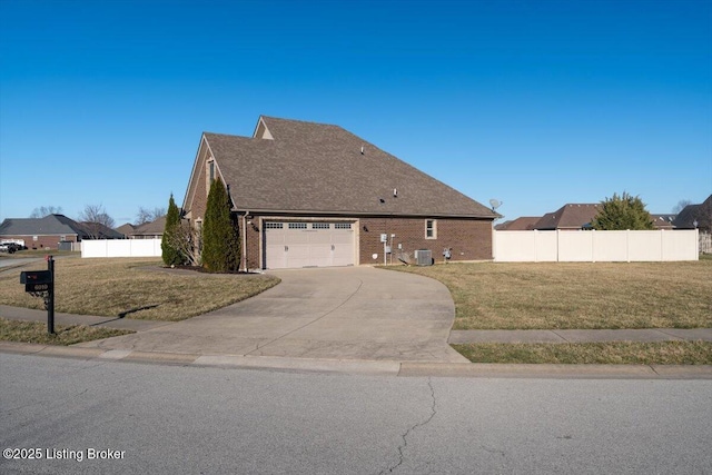 view of front of house with brick siding, concrete driveway, a front yard, fence, and cooling unit