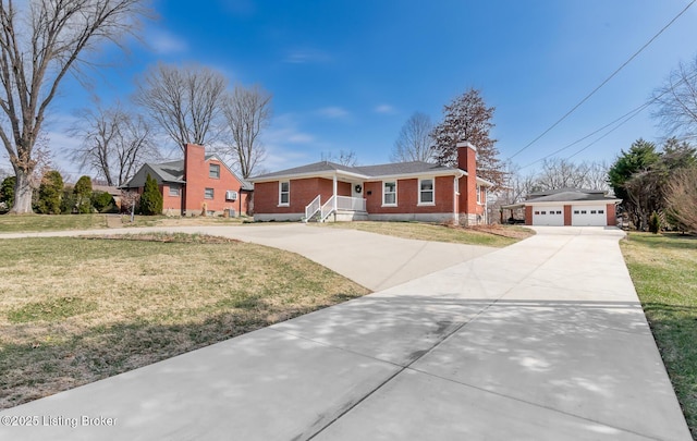 view of front of house with brick siding, a front yard, a chimney, a garage, and an outbuilding