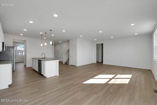 kitchen featuring light wood-type flooring, white cabinets, stainless steel appliances, and open floor plan