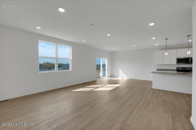 unfurnished living room with baseboards, visible vents, light wood-style flooring, and recessed lighting