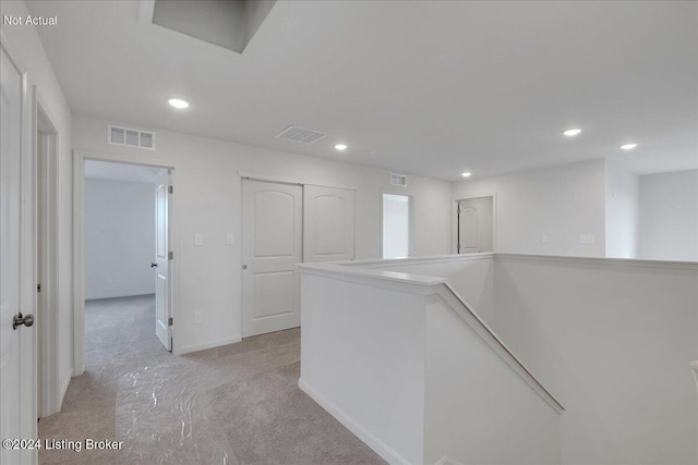 hallway featuring light colored carpet, visible vents, an upstairs landing, and recessed lighting