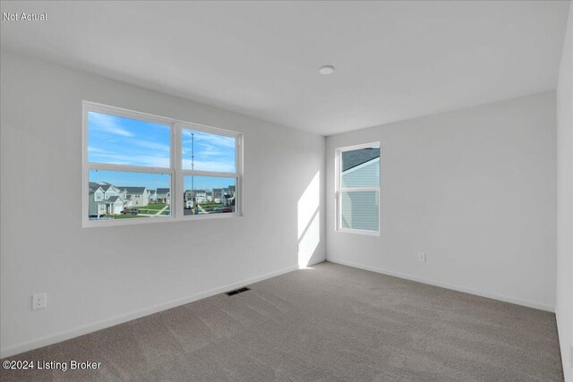 carpeted spare room featuring baseboards and visible vents