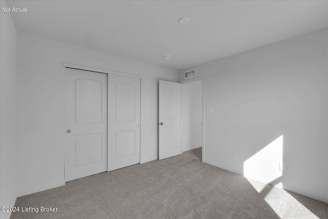 unfurnished bedroom featuring a closet, visible vents, and carpet flooring