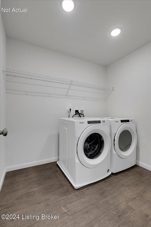 clothes washing area featuring laundry area, baseboards, washer and clothes dryer, and wood finished floors