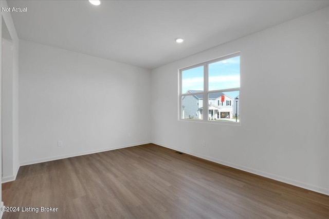 unfurnished room with visible vents, baseboards, wood finished floors, and recessed lighting