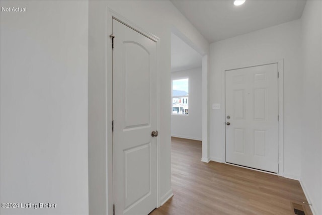 corridor with light wood-type flooring and visible vents