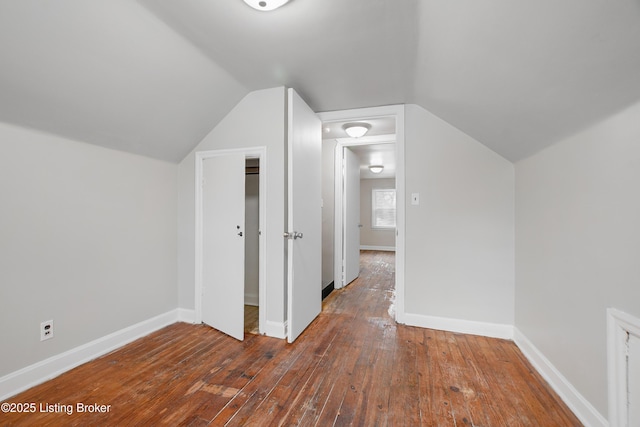 bonus room with lofted ceiling, hardwood / wood-style flooring, and baseboards