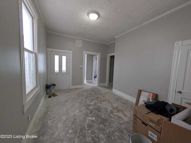 carpeted entryway with a textured ceiling, baseboards, and crown molding