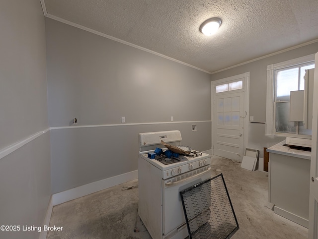 interior space with a textured ceiling, baseboards, light countertops, gas range gas stove, and crown molding