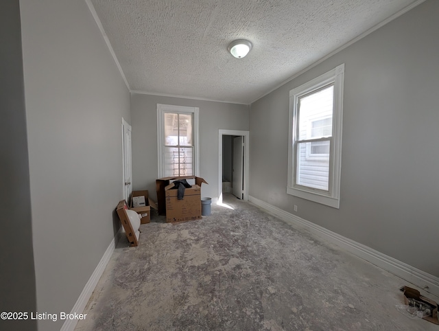 interior space with a healthy amount of sunlight, baseboards, and crown molding