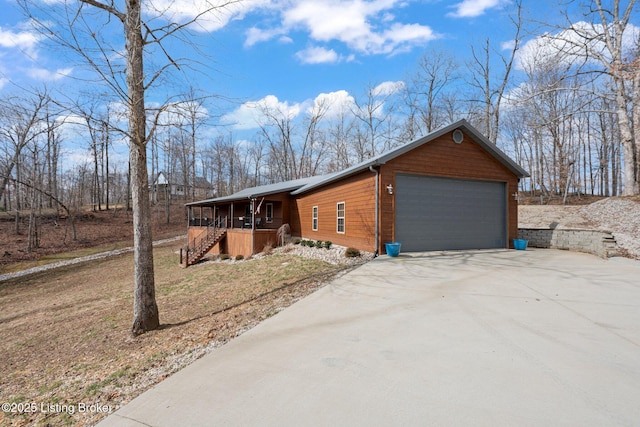 view of side of property featuring a garage and covered porch