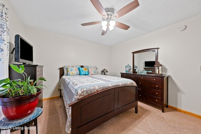 bedroom featuring baseboards, a ceiling fan, and light colored carpet