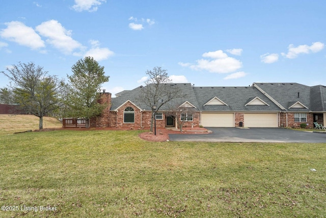 view of front of property featuring brick siding, a chimney, an attached garage, driveway, and a front lawn