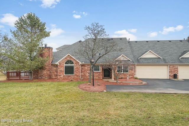 view of front of home with a chimney, aphalt driveway, roof with shingles, a front yard, and brick siding