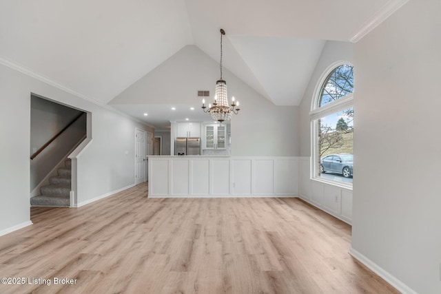 unfurnished dining area with light wood-style flooring, visible vents, crown molding, and stairway