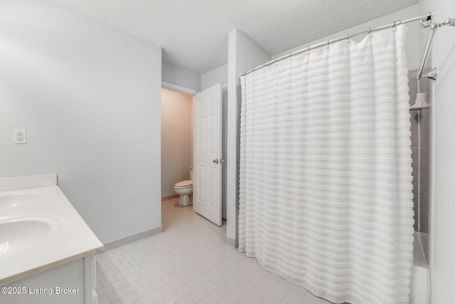 bathroom with curtained shower, a textured ceiling, toilet, and vanity