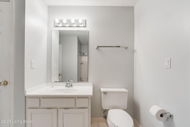 bathroom with a textured ceiling, vanity, toilet, and baseboards