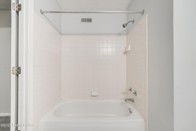 bathroom featuring a textured ceiling, shower / bathtub combination, and visible vents