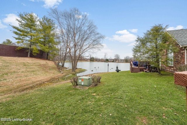 view of yard with a deck with water view and fence