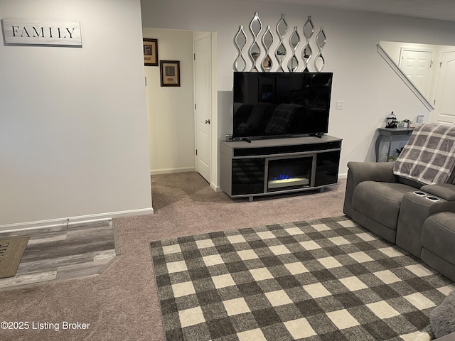 unfurnished living room with carpet and baseboards