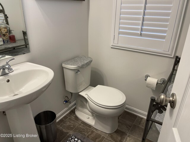 bathroom with baseboards and toilet