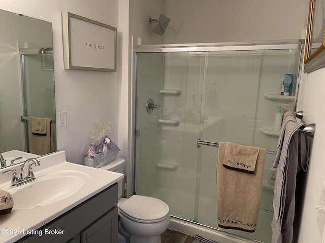 full bathroom featuring toilet, a stall shower, and vanity