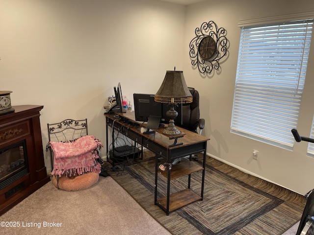 office area with carpet, baseboards, and a glass covered fireplace