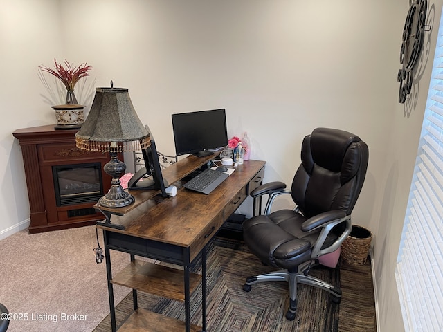 carpeted home office featuring baseboards