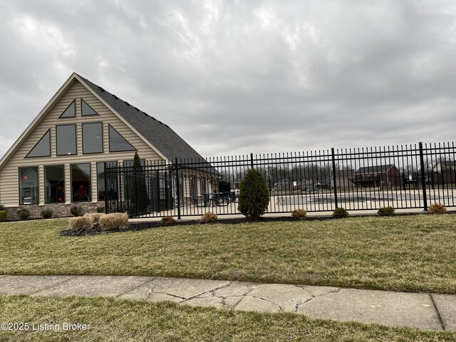 view of community with a lawn and fence