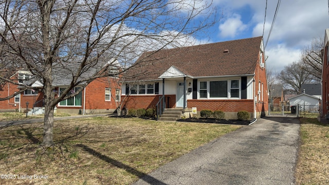 bungalow-style home featuring brick siding, roof with shingles, a gate, crawl space, and fence