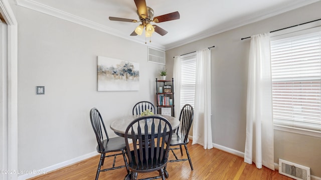 dining area with light wood finished floors, baseboards, visible vents, ceiling fan, and ornamental molding