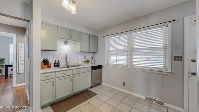 kitchen featuring tasteful backsplash, visible vents, dishwasher, light countertops, and a sink