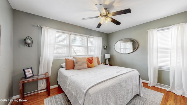 bedroom featuring ceiling fan, baseboards, and wood finished floors