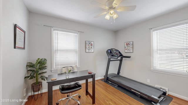 workout area featuring ceiling fan, baseboards, and wood finished floors