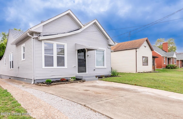 bungalow featuring entry steps, a front lawn, and roof with shingles