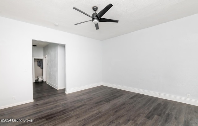 empty room featuring dark wood finished floors, a textured ceiling, baseboards, and ceiling fan