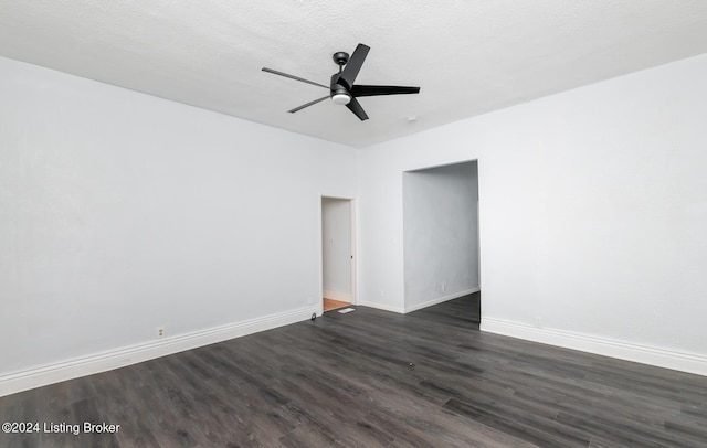 empty room with dark wood-style flooring, ceiling fan, a textured ceiling, and baseboards