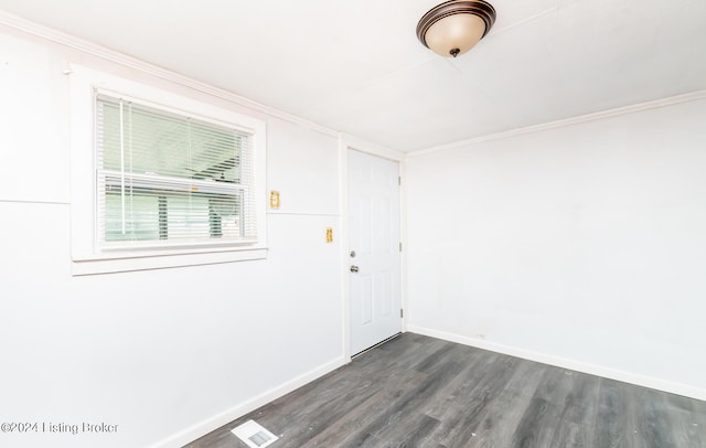 unfurnished room with crown molding, baseboards, and dark wood-type flooring