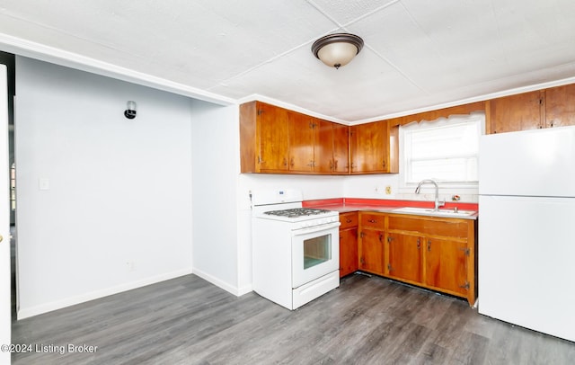 kitchen with white appliances, dark wood-type flooring, a sink, baseboards, and brown cabinets