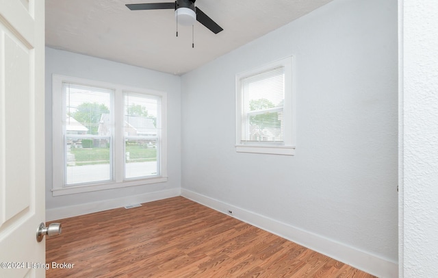 unfurnished room featuring a ceiling fan, visible vents, baseboards, and wood finished floors