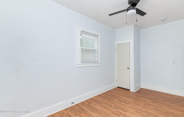 spare room featuring light wood-style flooring, baseboards, and ceiling fan