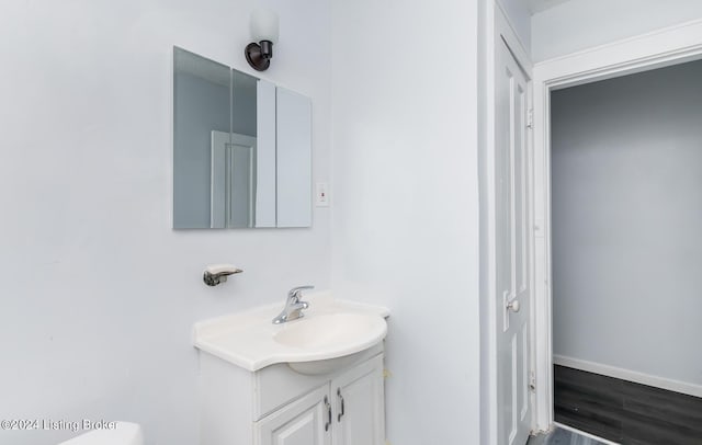 bathroom featuring wood finished floors, vanity, and baseboards