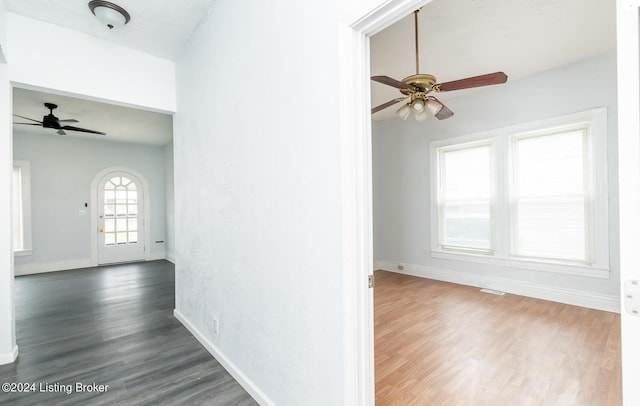 interior space featuring ceiling fan, wood finished floors, visible vents, and baseboards