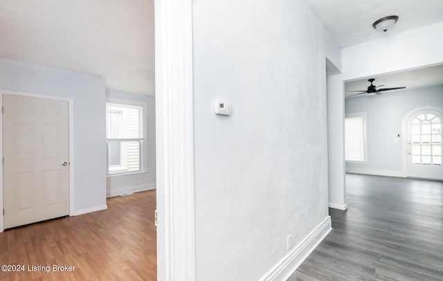 hallway with wood finished floors and baseboards