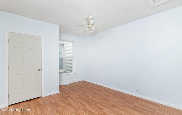 empty room featuring baseboards, a ceiling fan, and light wood-style floors