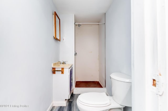 bathroom with vanity, wood finished floors, toilet, and baseboards